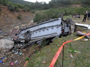 Tunisian security forces check the debris of a bus that plunged over a cliff into a ravine, in Ain Snoussi in northern Tunisia on December 1, 2019. - The bus, with 43 people on board had set off from the capital Tunis to the mountain town of Ain Draham, the tourism ministry said. About twenty-four people were reported killed and more than 18 injured.