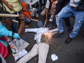 Demonstrators from the National Congress Party (NCP) beat and burn a dummy of a rapist as they protest against rapes in Ranchi, Vadodara, Surat and other regions, following the alleged rape and murder of a 27-year-old veterinary doctor in Hyderabad, in Ahmedabad on Dec. 4, 2019. (SAM PANTHAKY/AFP via Getty Images)
