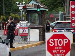 A guard stands by at the Nimitz Gate of Pearl Harbor in Hawaii shortly after a sailor fatally shot two civilians at the Pearl Harbor Naval Shipyard in Honolulu, Hawaii on Dec. 4, 2019.  (RONEN ZILBERMAN/AFP via Getty Images)