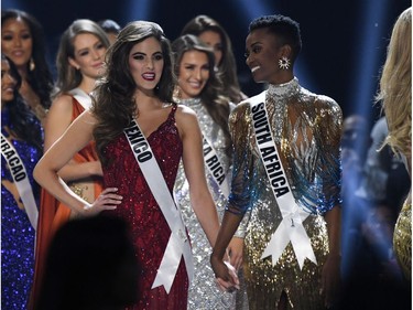 Miss Mexico Sofia Aragon and Miss South Africa Zozibini Tunzi hold hands on stage during a break in the 2019 Miss Universe pageant at the Tyler Perry Studios in Atlanta, Ga., on Dec. 8, 2019.