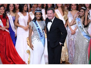 Newly crowned Miss World 2019 Miss Jamaica Toni-Ann Singh smiles as she poses with TV presenter Piers Morgan (R) during the Miss World Final 2019 at the Excel arena in east London on Dec. 14, 2019.
