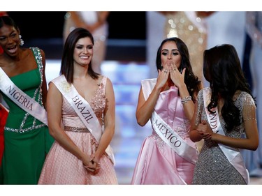 Ashley Alvidrez of Mexico and Elis Coelho of Brazil react on stage during the Miss World final in London, Britain