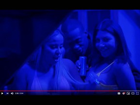 Marcella Zoia, aka Chair Girl, left, is seen in a screengrab from Drake's new video War, from which she has since been edited out.