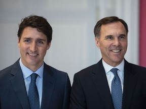 Prime Minister Justin Trudeau stands with Bill Morneau as he remains finance minister during the swearing in of the new cabinet at Rideau Hall in Ottawa on Wednesday, Nov. 20, 2019.