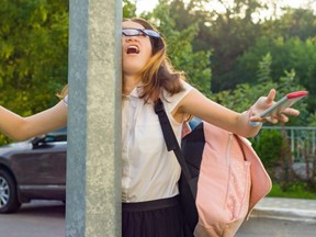 Portrait of young inattentive girl, distracted by mobile phone. Girl crashed into street post, dropped phone