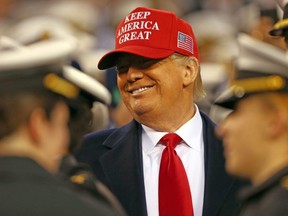 U.S. President Donald Trump smiles while talking to Naval Academy Midshipmen in the seats during the second half of the Army vs. Navy football game at Lincoln Financial Field in Philadelphia, Saturday, Dec. 14, 2019.