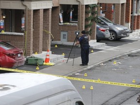 Police collect evidence at the scene of a deadly shooting outside a townhome on Chevron Prince Path in Oshawa on Tuesday.