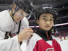 Tyler Tang, 9, gets an autograph from Senators defenceman Erik Brannstrom during the 16th annual Eugene Melnyk Skate for Kids at Canadian Tire Centre on Friday, Dec. 20. (WAYNE CUDDINGTON/POSTMEDIA NETWORK)