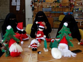 Palestinian women wearing face veil, niqab, make Santa-themed Christmas toys in the northern Gaza Strip Dec. 29, 2019.