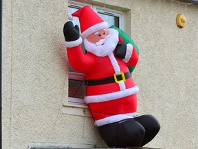 In this Dec. 18, 2014 file photo, a giant inflatable Santa is seen perched above a bay window in Knightswood as suburbia lights up for Christmas in Glasgow Scotland. (Mark Runnacles/Getty Images)