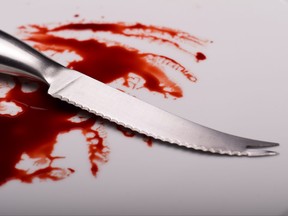 Knife on white plate with blood