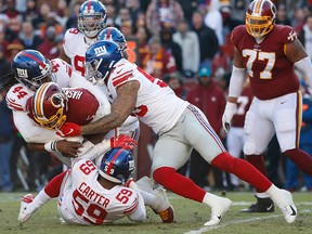 Washington Redskins quarterback Dwayne Haskins is sacked by New York Giants linebacker Markus Golden and Giants linebacker Lorenzo Carter in the second quarter at FedExField in Landover, Md., on Dec. 22, 2019.