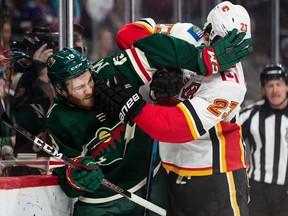 Minnesota Wild centre Luke Kunin and Calgary Flames centre Sean Monahan fight for the puck along the boards during the second period at Xcel Energy Center on Monday in St. Paul, Minn.