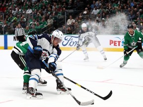 Winnipeg Jets’ Andrew Copp skates past Stars’ Miro Heiskanen last night at American Airlines Center in Dallas. (Getty images)