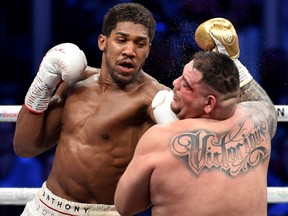 British boxer Anthony Joshua (white trunks) competes with Mexican-American boxer Andy Ruiz Jr. (golden trunks) during the heavyweight boxing match between Andy Ruiz Jr. and Anthony Joshua for the IBF, WBA, WBO and IBO titles in Diriya, near the Saudi capital on Dec. 7, 2019.