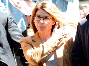 Lori Loughlin (C) arrives at the court to appear before Judge M. Page Kelley to face charges for allegedly conspiring to commit mail fraud and other charges in the college admissions scandal at the John Joseph Moakley United States Courthouse in Boston on April 3, 2019.