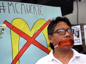 A man protests outside a closed McDonald's restaurant, after the deaths of two teenaged employees, in Lima, Peru December 21, 2019. (REUTERS/Guadalupe Pardo)