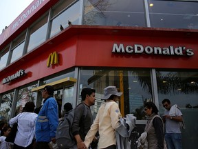 People walk past McDonald's in Lima, Peru, Oct. 1, 2017.