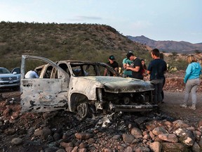 Members of the Lebaron family look at the burned car where some of the nine murdered members of the family were killed and burned during an ambush at Bavispe, Mexico, on November 5, 2019. (HERIKA MARTINEZ/AFP via Getty Images)