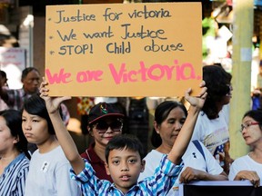A protester holds up a placard demanding justice for Victoria, an alleged victim of child rape, in Yangon, Myanmar, December 23, 2019.