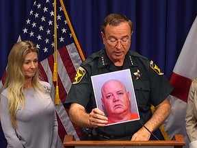 Polk County Sheriff Grady Judd holds up a photo of suspect Rodney Davis during a press conference Wednesday. (Video screen grab)