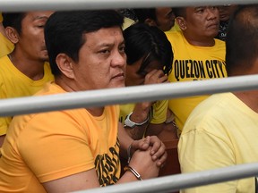 This handout photo from the Supreme Court - Public Information Office (SC-PIO)  taken and released on Dec. 19, 2019 shows Andal Ampatuan Jr. (L) and others accused of involvement in the 2009 Maguindanao massacre waiting to hear the court's verdict at the trial venue inside a prison facility in Manila.
