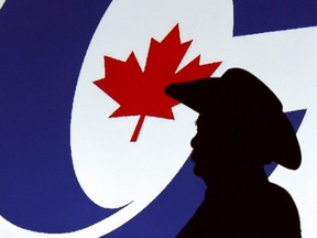 A forum visitor is silhouetted in front of a projected logo before a Conservative Party leadership candidate forum at the Deerfoot Inn and Casino in Calgary, Alta. on Wednesday March 1, 2017.