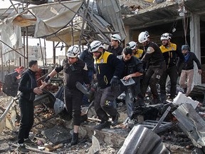 Members of the Syrian Civil Defence (White Helmets) recover a victim following a regime air strike on December 2, 2019 in a market in the town of Maaret al-Numan. (ABDULAZIZ KETAZ/AFP via Getty Images)
