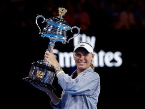 Denmark's Caroline Wozniacki celebrates with the trophy after winning the final against Romania's Simona Halep.