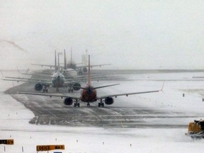 A snowplow clears a runway near a line of jets waiting to takeoff after a pre-Thanksgiving holiday snowstorm caused more than 460 flight cancellations at Denver International Airport, Colorado, U.S., November 26, 2019.
