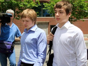 In this July 1, 2010 file photo, Alexander Vavilov, right, and his older brother brother Timothy leave a federal court after a bail hearing for their parents Donald Heathfield and Tracey Ann Foley, in Boston.