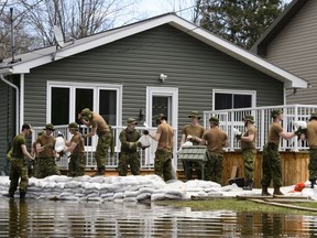 Soldiers work to hold back flood waters on the Ottawa River in Cumberland, Ont. on Tuesday, April 30, 2019. (THE CANADIAN PRESS/Sean Kilpatrick)