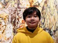 Xeo Chu, a Vietnamese art prodigy, poses in front of one of his pieces before his debut solo exhibition at the Georges Berges Gallery in New York City, Dec. 18, 2019.