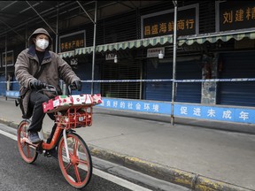 A man wears a mask while riding on mobike past the closed Huanan Seafood Wholesale Market, which has been linked to cases of Coronavirus, on Jan. 17, 2020 in Wuhan, Hubei province, China. (Getty Images)