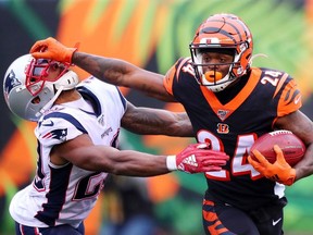 Darius Phillips of the Cincinnati Bengals stiff arms Justin Bethel of the New England Patriots on a kickoff return during the second half in the game at Paul Brown Stadium on December 15, 2019 in Cincinnati, Ohio.
