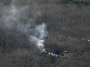 Wreckage of the crashed helicopter that was carrying former NBA star Kobe Bryant and his 13-year-old daughter Gianna smolders on the ground on January 26, 2020 in Calabasas, California.