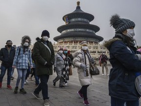 Visitors wear protective masks as they tour the grounds of the Temple of Heaven, which remained open during the Chinese New Year and Spring Festival holiday on January 27, 2020 in Beijing, China.