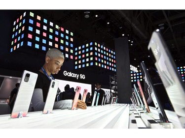 A Samsung representative adjusts  the Galaxy A71 display at the Samsung booth during CES 2020 at the Las Vegas Convention Center on Jan. 8, 2020 in Las Vegas on Jan. 8, 2020.