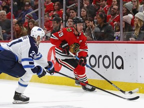 Jonathan Toews of the Chicago Blackhawks controls the puck under pressure from Nicholas Shore of the Winnipeg Jets at the United Center on Sunday, Jan. 19, 2020.