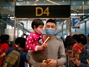 A Chinese tourist wears a mask as he arrives at Suvarnabhumi Airport during a welcome ceremony of Chinese Lunar New Year travellers in Bangkok, Thailand Jan. 22, 2020. (REUTERS/Soe Zeya Tun)