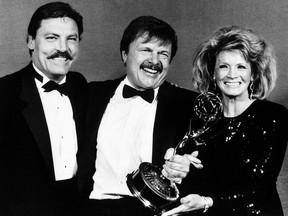 This Sept. 21, 1986 file photo shows actor John Karlen, centre, who portrays the husband of detective Mary Beth Lacey on the TV show "Cagney & Lacey, " posing with presenters Stacy Keach, left, and Angie Dickinson after Karlen won an Emmy for best supporting actor at the Emmy Awards in Pasadena, Calif.  (AP Photo/Douglas C. Pizac, File)
