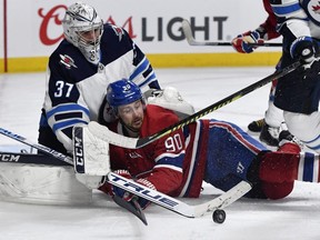 Winnipeg Jets goalie Connor Hellebuyck (37) stops the puck and Montreal Canadiens forward Tomas Tatar (90) during the second period at the Bell Centre.