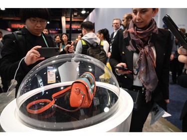 Attendees look at a purse with an integrated Royole Flexpai flexible display, Jan. 8, 2020, at the Computer Electronics Show (CES) in Las Vegas.