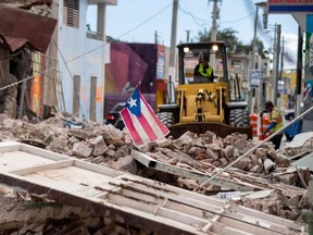 In this file photo taken on January 8, 2020, A Puerto Rican flag waves on top of a pile of rubble as debris is removed from a main road in Guanica, Puerto Rico, after the January 7 earthquake. - A 6.0 magnitude earthquake rocked Puerto Rico on January 11, 2020, the latest in a series of powerful tremors that have struck the US territory in recent days, the US Geological Survey reported. The latest quake was felt at 8:54 am local time (1254 GMT) 14 kilometers (eight miles) southeast of Guanica, a town on the island's southern Caribbean coastline that was hard hit by earlier quakes.