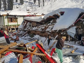 Local residents remove debris of a collapsed house following heavy snowfall that triggered an avalanche in Neelum Valley, in Pakistan-administered Kashmir on January 14, 2020.