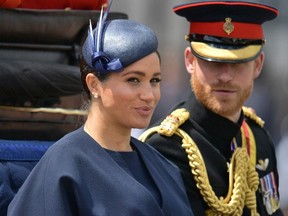 In this file photo taken on June 8, 2019 Britain's Meghan, Duchess of Sussex (L) and Britain's Prince Harry, Duke of Sussex (R) return to Buckingham Palace after the Queen's Birthday Parade, 'Trooping the Colour', in London.