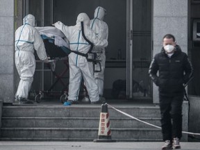 Medical staff members carry a patient into the Jinyintan hospital, where patients infected by a mysterious SARS-like virus are being treated, in Wuhan in China's central Hubei province on January 18, 2020.