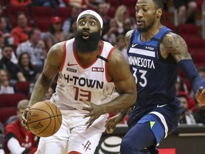 Houston Rockets guard James Harden dribbles the ball as Minnesota Timberwolves forward Robert Covington defends during the first quarter at Toyota Center.