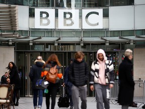 Pedestrians walk past a BBC logo at Broadcasting House, as the corporation announced it will cut around 450 jobs from its news division, in London, England, Jan. 29, 2020.