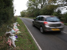 In this file photo taken on October 10, 2019, floral tributes lay on the roadside near RAF Croughton in Northamptonshire, at the spot where British motorcyclist Harry Dunn was killed as he travelled along the B4031 on August 27. (LINDSEY PARNABY/AFP via Getty Images)